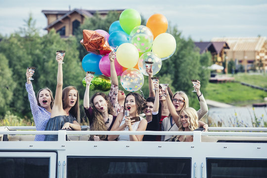 Young beautiful happy women celebrate bachelorette party in a convertible limousine
