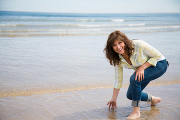 Beautiful middle aged woman having fun on the beach