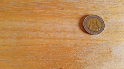 Thailand coin on the wooden floor.