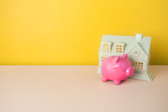 home and piggy bank in money finance concept