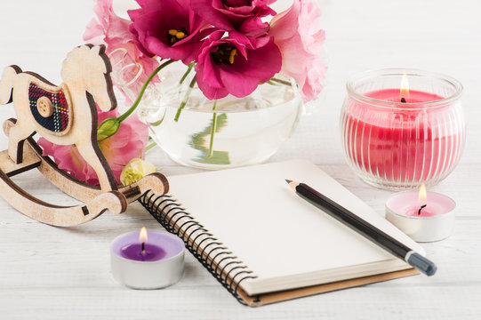 Blank notebook, candles, eustoma flowers