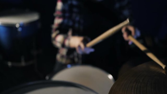 Young Emotional Rock girl percussion drummer performing with drums, slow motion. Attractive young woman plays the drums