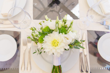 Wedding bouquet lies on the plate.