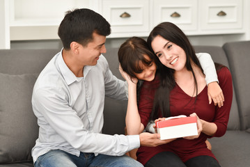 young family holding gift box.