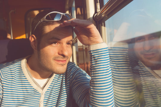 Mann mit Sonnenbrille im Zugabteil
