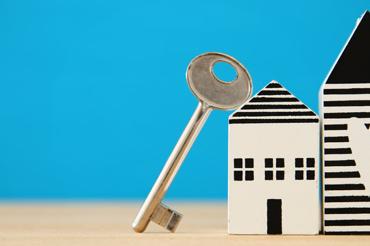 small house model with key over wooden floor. selective focus