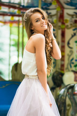 cool real teenage girl near carousels at amusement park walking