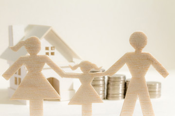 A family and home with model and coin stack on paper background, the saving money for real estate owner in the future concept.