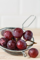 bunch of red grapes on a wooden table. 