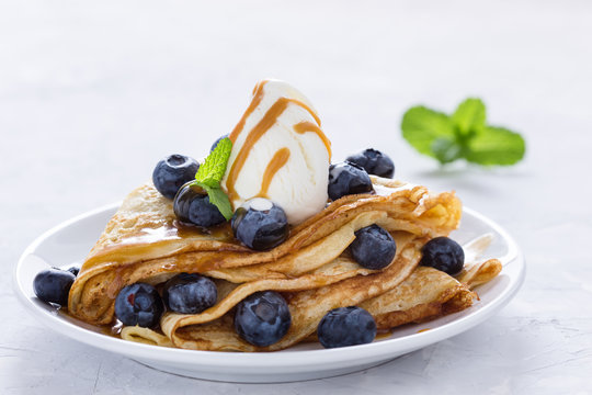 Crepes served with fresh blueberries, ice cream and caramel sauce
