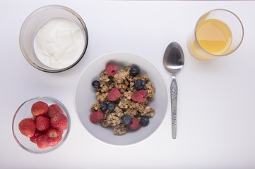 Bowl of granola with yogurt, strawberries and orange juice 