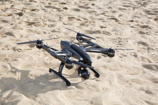Flying drone with mounted camera on the beach
