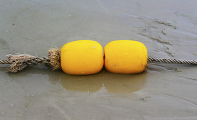 Yellow buoy and sand beach