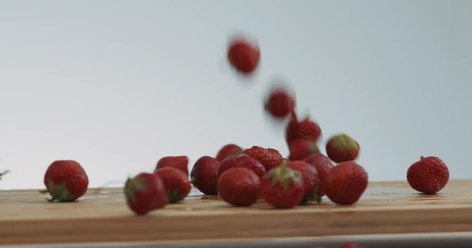 Erdbeeren fallen auf ein Holzbrett - Brettchen - Holz