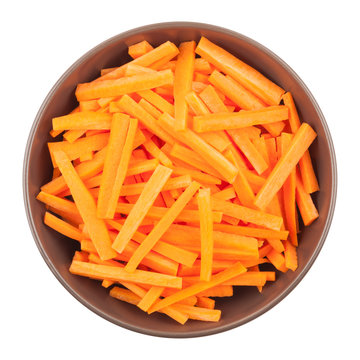 Ceramic bowl with chopped carrots isolated on white background, top view