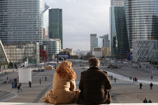 Rear view of couple sitting together and looking at city