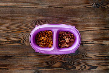 Cat feed in bowl on wooden background top view copyspace