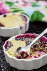 Homemade delicious crumble with berries in portioned individual ramekins. Healthy breakfast concept. Selective focus