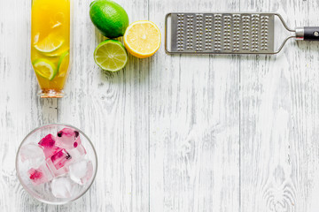 Making lemonade. Cookware, fruits and bottle of lemonade on wooden table background top view copyspace