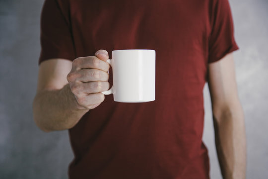 Man In Red T-shirt Holding Big White Coffee Cup.Mock Up Of Clean Coffee Cup.Horizontal Mockup.