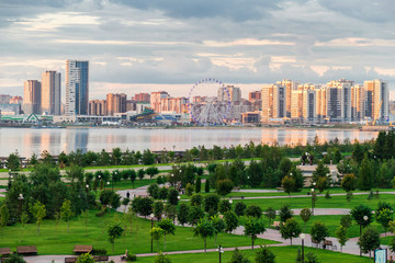 Beautiful urban landscape with a road, a Park and a lake at sunset