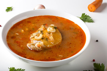 Chicken soup with noodles and vegetables in white bowl