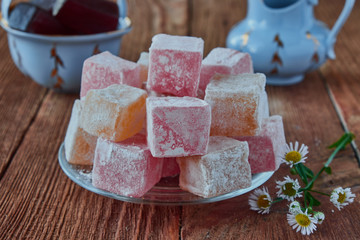 Delicious Turkish delight with tea on a wooden background