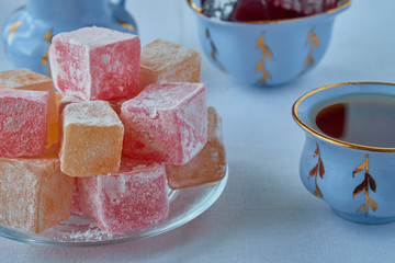 Delicious Turkish delight with tea on a wooden background