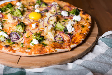 Delicious fresh homemade pizza with onions, vegetables and cheese on a wooden table. Copy space. close-up.