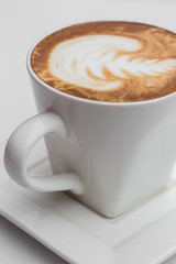 Close up white coffee Coffee cup. latte art on wood table at cafe