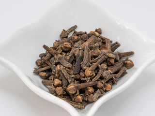 Clove spice. Carnation seasoning. A pile of carnations isolated on a white background. Natural spices