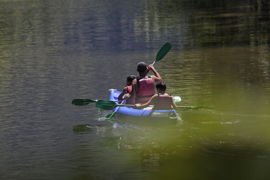 Un padre rema con sus hijos en las vacaciones de verano