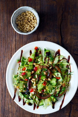 Healthy homemade green salad with nuts and sauce top view 