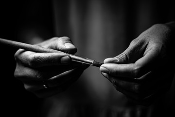 The artist's hands hold a brush