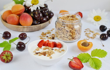 Healthy Fresh Breakfast Yogurt with Granola Fruits Berries Strawberries Apricot Melon Cherry Chamomile Close up White Background