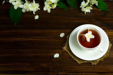 Tea with jasmine in a white mug on a wooden table