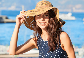 lovely girl in a hat protects her face from the sun - 164214863