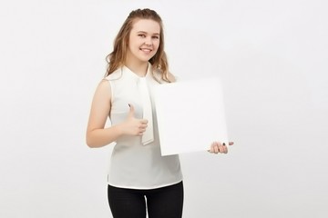 Young woman holding blank poster.Smiling woman sign board holding. Girl showing banner with copy...