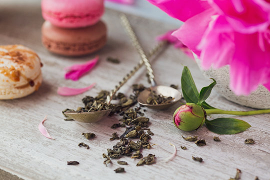 Still life with pink peony flowers and a cup of herbal or green tea