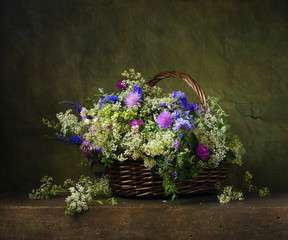 Still life with wild flowers in a basket