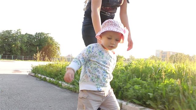 Mom and baby gerl walk along the path