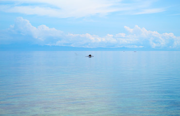 Fototapeta na wymiar Seascape with fisherman boat and blue sky. Relaxing sea view with still seawater.