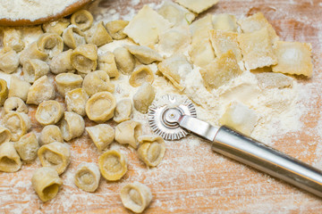 Italian ravioli on a wooden vintage wooden board, sprinkled with flour. Ravioli homemade. Top view.