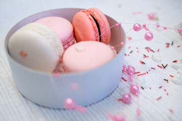 Pastel pink and rose macaroons in a white deep paper bowl