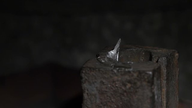 Pouring molten lead alloy into a mold. Workshop. Manufactory, manual manufacturing of lead alloy .An employee at the plant craft while working. Pouring molten lead alloy into a mold