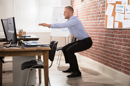 Businessman Doing Exercise In Office