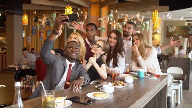 Multinational group of friends in a cafe doing selfi