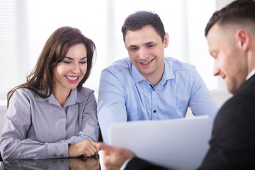 Fototapeta premium Couple Having Discussion With Advisor In Office