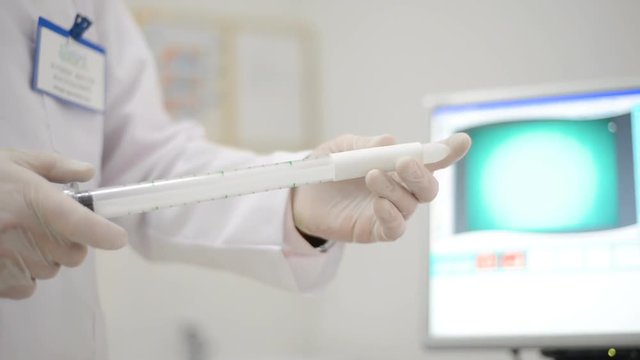 proctologist doctor holding anoscope (proctoscope) Ligador hemorroidal in office