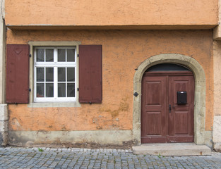 Fototapeta na wymiar Old door and window on classical old wall in Europe